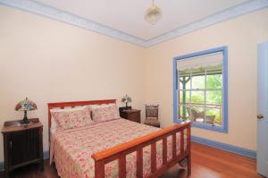 a bedroom with a bed and a window at Magnolia Cottage Kangaroo Valley in Barrengarry