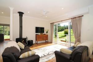 a living room with a couch and a fireplace at Nellsville Cottage Kangaroo Valley in Upper Kangaroo River