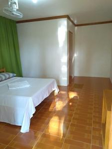 a bedroom with a bed and a tiled floor at Gold Star Inn in Siquijor