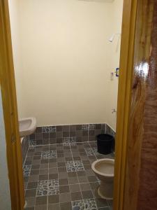 a bathroom with a toilet and a tiled floor at Gold Star Inn in Siquijor