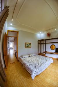 - une chambre avec un grand lit et du parquet dans l'établissement Quang Ngai Hostel, à Quảng Ngãi