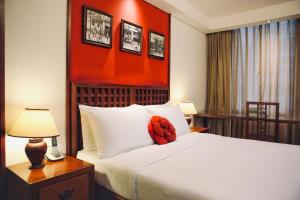 a hotel room with a bed with an orange wall at Butterfly on Wellington, Central in Hong Kong