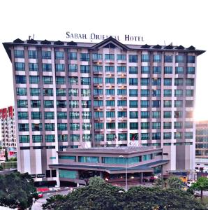 ein großes Hotel mit einem Schild darüber in der Unterkunft Sabah Oriental Hotel in Kota Kinabalu