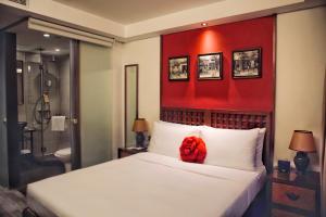 a red teddy bear sitting on a bed in a bedroom at Butterfly on Wellington, Central in Hong Kong