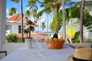 Beach Villas & Apartments Larimar في بونتا كانا: طاولة مع كؤوس للنبيذ وسلة من الفواكه