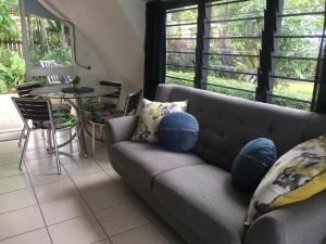 a living room with a gray couch with blue pillows at Casablanca Domes Trinity Beach in Trinity Beach