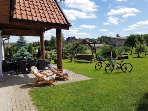 a gazebo with two chairs and two bikes in a yard at Na Skraju Warmii in Barczewo