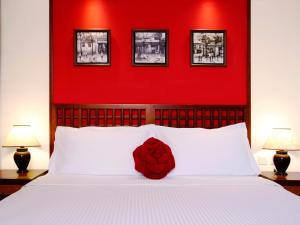 a red wall above a bed with a red headboard at Butterfly on Wellington, Central in Hong Kong