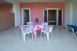 a table and chairs on a patio with a pink table cloth at Villa Rebecca in Agios Gordios