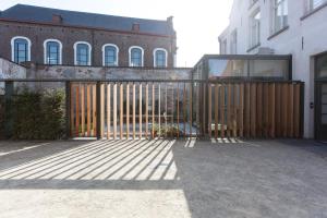 a wooden gate in front of a building at B&B La Suite in Bruges