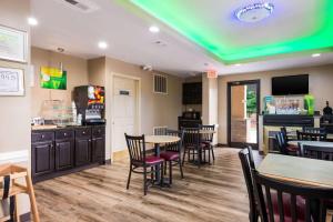 een restaurant met tafels en stoelen en een groen plafond bij Quality Inn & Suites in Rockingham