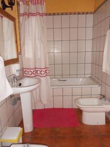 a bathroom with a sink and a toilet and a tub at La Mesnadita in Olmedo