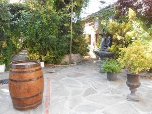 un jardín con un barril, una estatua y una fuente en La Mesnadita, en Olmedo