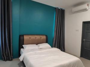 a bed in a room with a blue wall at Bilek@KADOK in Kota Bharu