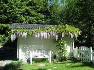 eine weiße Pergola mit einer Bank in einem Garten in der Unterkunft Allgäuvilla in Scheidegg