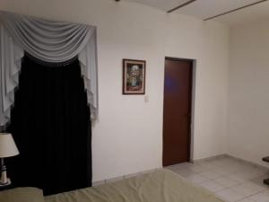 een witte kamer met een zwart gordijn en een deur bij Martha´s HOUSE in Culiacán