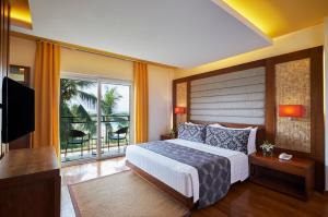 a bedroom with a large bed and a balcony at Movenpick Resort & Spa Boracay in Boracay
