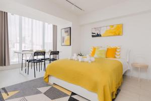 1 dormitorio con 1 cama amarilla, mesa y sillas en Hotel Apartment Ueno Inaricho Sta, en Tokio