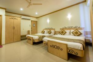 ムンバイにあるGarden Hotelのベッド2台とバスルームが備わるホテルルームです。