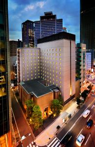 a large building in a city with cars on a street at RIHGA PLACE HIGOBASHI in Osaka