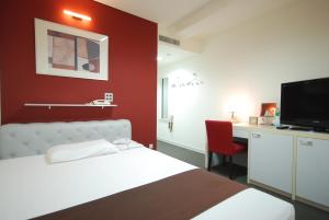 a hotel room with a bed and a desk and a tv at Kokusai Hotel Yamaguchi in Yamaguchi