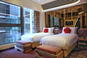 香港にあるButterfly on LKF Boutique Hotel Centralのベッド2台と窓が備わるホテルルームです。