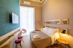 a bedroom with a bed with two stools and a window at The Duomo House by House In Naples in Naples