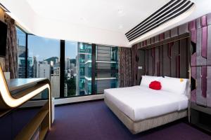 um quarto de hotel com uma cama e uma janela grande em Butterfly on LKF, Central em Hong Kong