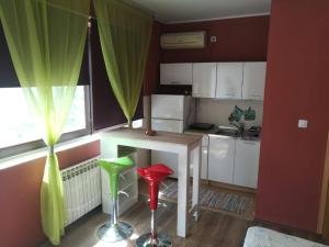 a kitchen with a table and two red and green stools at City Break Studio Apartment in Zagreb