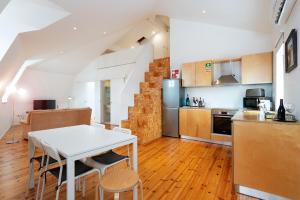 cocina y comedor con mesa blanca y sillas en Apartamentos Premium Familiares - Loft Guesthouse BeMyGuest Viseu en Viseu