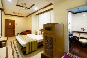 ムンバイにあるGarden Hotelのベッドとバスルーム付きのホテルルームです。