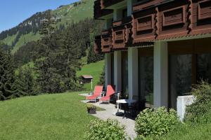 einer Gruppe von Stühlen und einem Tisch an der Seite eines Gebäudes in der Unterkunft Appartment Schröcken in Schröcken