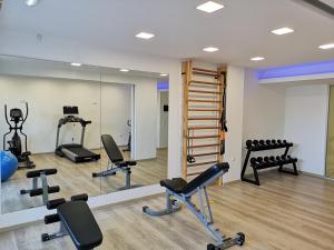 een fitnessruimte met diverse fitnessapparatuur en een spiegel bij Dimitra Hotel in Chersonissos