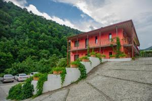 a red building with plants on the side of it at Ariana Family Hotel in Dilijan
