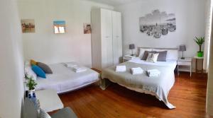 two beds in a room with wooden floors at Cascais Seaside Garden Villa in Cascais