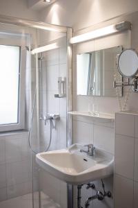 a white bathroom with a sink and a shower at Gasthof Gosauschmied in Gosau