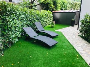 dwa krzesła siedzące na trawie w ogrodzie w obiekcie Apartments Eva w mieście Malinska