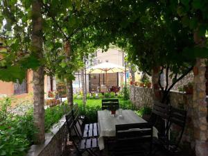a table and chairs under trees in a garden at Casa Ysa in Vama Veche