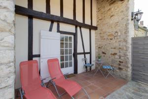 a patio with red chairs and a table at Domaine des Trois chateaux in Moisenay