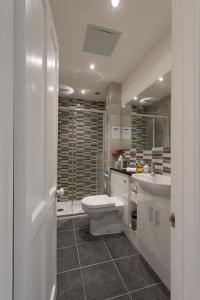 uma casa de banho branca com um WC e um lavatório em Cliftons Guest House em Truro