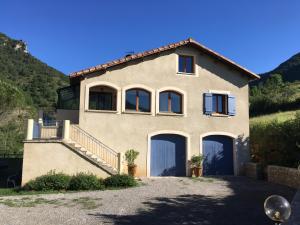 a house with two garage doors on a hill at Villa le Tresquel in Mostuéjouls