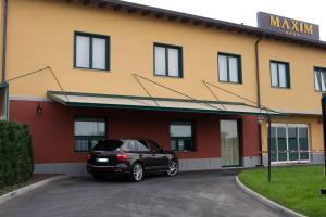 a black car parked in front of a building at Hotel Maxim in Anzola dell'Emilia