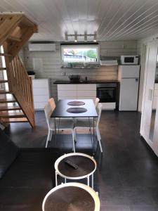 uma cozinha e sala de jantar com mesa e cadeiras em Stugcentralen Stuga 24 em Halmstad