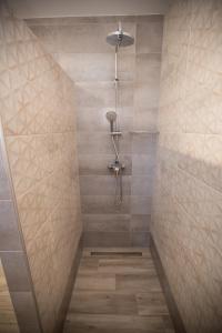 a shower with a shower head in a bathroom at Villa Jandia Modern new apartment Morro Jable Private heated pool big terrace and parking in Morro del Jable