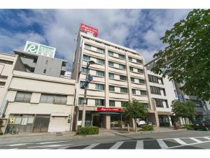 高松市にあるハイパーイン高松駅前の横断歩道のある街路の白い大きな建物