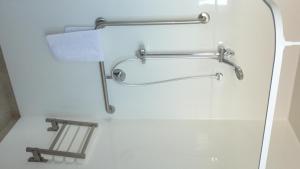 La salle de bains est pourvue d'un sèche-serviettes et de toilettes. dans l'établissement Colonial Inn Motel, à Christchurch