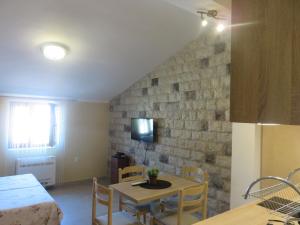 Pokój ze stołem i krzesłami oraz kamienną ścianą w obiekcie Villa Adriatic w Kotorze