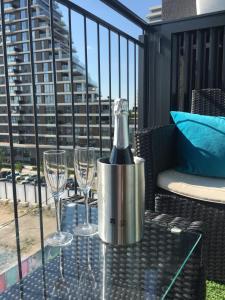 una botella de vino en una mesa con copas en el balcón en Belgrade Waterfront - Beograd na vodi, en Belgrado