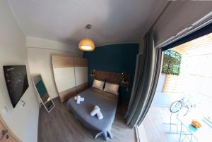 a small living room with a blue couch and a window at veraghi apartment 1 in Lefkada +4 photos