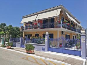 a yellow and blue building with balconies and plants at veraghi apartment 1 in Lefkada